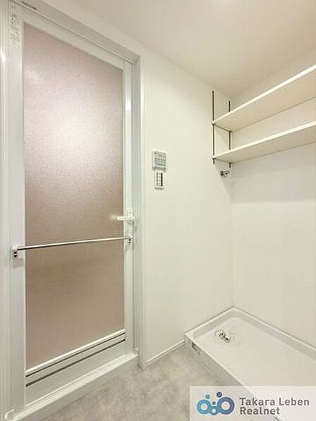 洗面スペースには防水パン付きの洗濯機置場があります。上部の棚は洗剤やタオルなどの収納に便利。