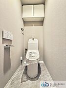 白を基調とした清潔感のあるトイレ。上部に収納もついておりますので、とても便利です。