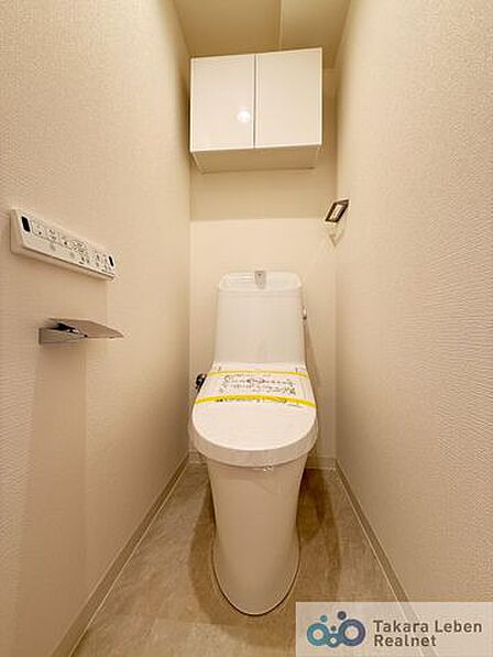 ウォシュレット機能付きのトイレは壁掛けリモコンの上位グレードを採用。便座がスッキリした印象となり、限られた空間を広く見せる効果があります。
