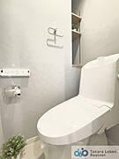 ウォシュレット機能付きのトイレは壁掛けリモコンの上位グレードを採用。便座がスッキリした印象となり、限られた空間を広く見せる効果があります。