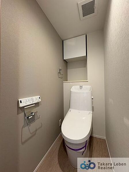 ウォシュレット機能付きのトイレは壁掛けリモコンの上位グレードを採用。便座がスッキリした印象となり、限られた空間を広く見せる効果があります。