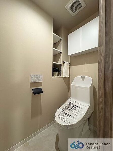 ウォシュレット機能付きのトイレは壁掛けリモコンの上位グレードを採用。便座がスッキリした印象となり、限られた空間を広く見せる効果があります。