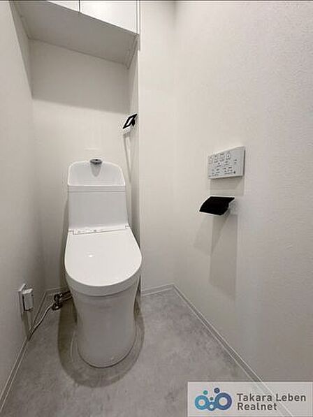 ウォシュレット機能付きのトイレは壁掛けリモコンの上位グレードを採用。便座がスッキリした印象となり、限られた空間を広く見せる効果があります。