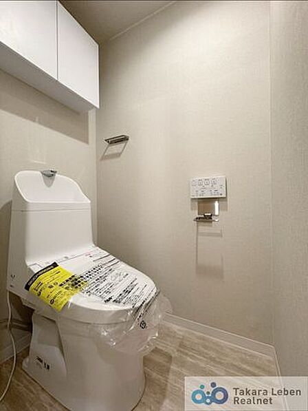 ウォシュレット機能付きのトイレは壁掛けリモコンの上位グレードを採用。便座がスッキリした印象となり、限られた空間を広く見せる効果があります。