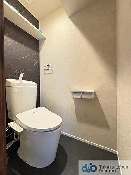 ウォシュレット機能付きのトイレは壁掛けリモコンの上位グレードを採用。便座がスッキリした印象となり、限られた空間を広く見せる効果があります。