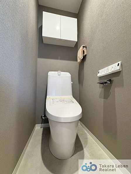 ウォシュレット機能付きのトイレは壁掛けリモコンの上位グレードを採用。便座がスッキリした印象となり、限られた空間を広く見せる効果があります。