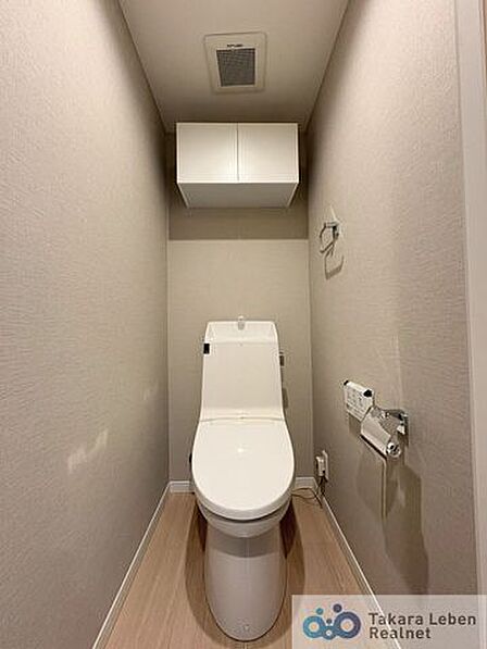 ウォシュレット機能付きのトイレは壁掛けリモコンの上位グレードを採用。便座がスッキリした印象となり、限られた空間を広く見せる効果があります。