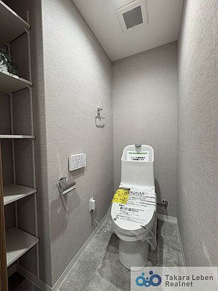 ウォシュレット機能付きのトイレは壁掛けリモコンの上位グレードを採用。便座がスッキリした印象となり、限られた空間を広く見せる効果があります。