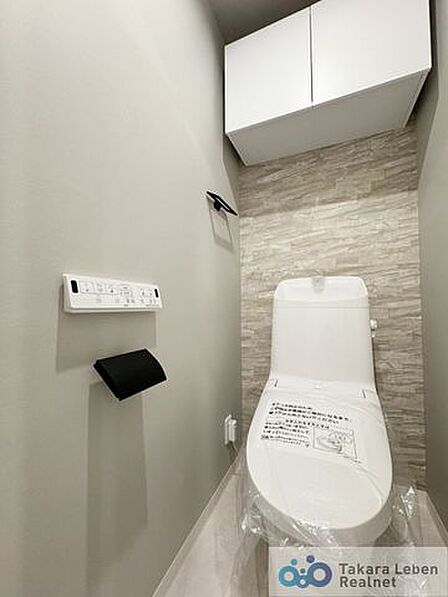 ウォシュレット機能付きのトイレは壁掛けリモコンの上位グレードを採用。便座がスッキリした印象となり、限られた空間を広く見せる効果があります。