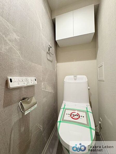 ウォシュレット機能付きのトイレは壁掛けリモコンの上位グレードを採用。便座がスッキリした印象となり、限られた空間を広く見せる効果があります。