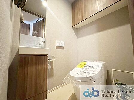 ウォシュレット機能付きのトイレは壁掛けリモコンの上位グレードを採用。便座がスッキリした印象となり、限られた空間を広く見せる効果があります。
