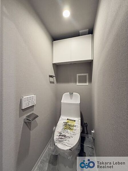 ウォシュレット機能付きのトイレは壁掛けリモコンの上位グレードを採用。便座がスッキリした印象となり、限られた空間を広く見せる効果があります。
