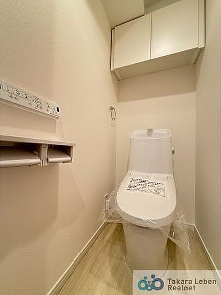 ウォシュレット機能付きのトイレは壁掛けリモコンの上位グレードを採用。便座がスッキリした印象となり、限られた空間を広く見せる効果があります。