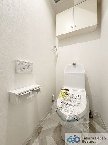 ウォシュレット機能付きのトイレは壁掛けリモコンの上位グレードを採用。便座がスッキリした印象となり、限られた空間を広く見せる効果があります。