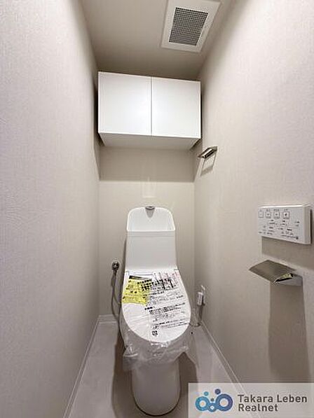 ウォシュレット機能付きのトイレは壁掛けリモコンの上位グレードを採用。便座がスッキリした印象となり、限られた空間を広く見せる効果があります。