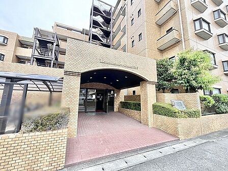 落ち着いた色調のタイルが重厚感を醸し出し、帰宅する人を温かく迎え入れる気品あるエントランスです。