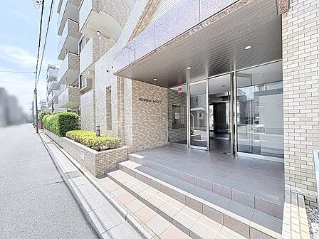 街並みに自然に溶け込むタイル張りの外観が、落ち着いた佇まいを感じさせるエントランスです。