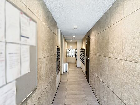 落ち着いた色調のタイルが洗練された印象を与え、静かな日常へと誘う共用スペース。