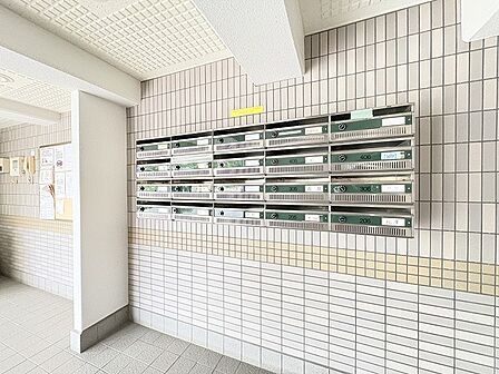 タイル貼りの壁面が整然と並ぶ共用部は、日常の往来を心地よく迎えてくれる落ち着いた佇まいです。