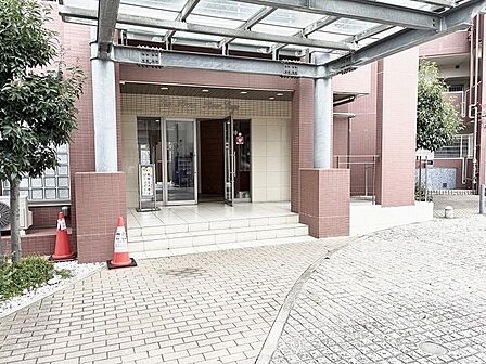 落ち着いた色合いのタイルとガラス屋根が調和する、品格漂う佇まいのエントランスです。