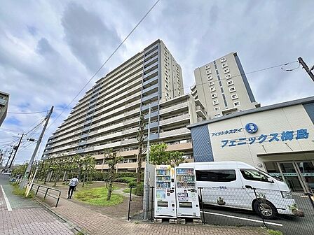 青空の下で堂々たる佇まいを見せる、落ち着いた色合いの美しい景観が日常に広がる住まい