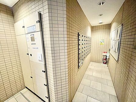 タイル貼りの壁面が落ち着いた表情を見せる整えられた共用スペース
