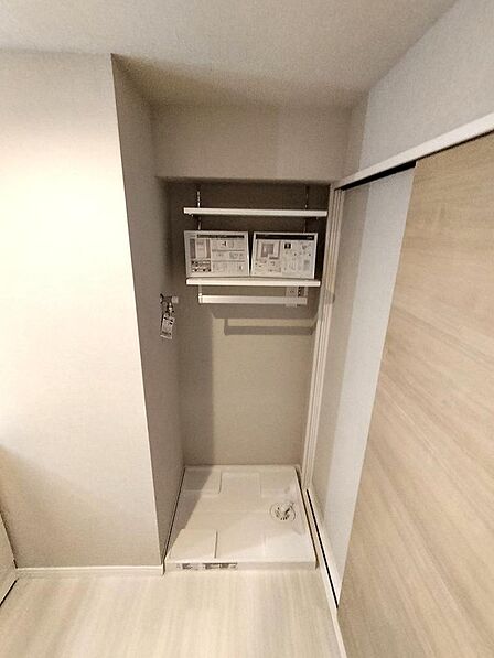上部に棚を設けた洗濯機置き場です。洗濯機防水パンも新規交換されています。