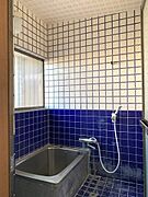 前面の壁に深みカラーを採用した、落ち着きのある浴室です