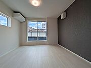 落ち着いたフローリングが上質な空間を演出する洋室。窓からの陽光が心地よく、寝室や書斎など多目的に活用できる、品格ある住空間です。