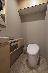 落ち着きのある内装のトイレです。室内に手洗い器を設けているため、使用後すぐに手を洗えて衛生的。上部に戸棚があり、予備のトイレットペーパーや掃除道具をすっきりと収納できます。