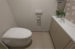 2026年2月交換済みのトイレ。掃除がしやすく見た目もスマートな、温水洗浄便座付きです。吊戸棚を備えているため、掃除用品やトイレットペーパーのストック類を収納できます。