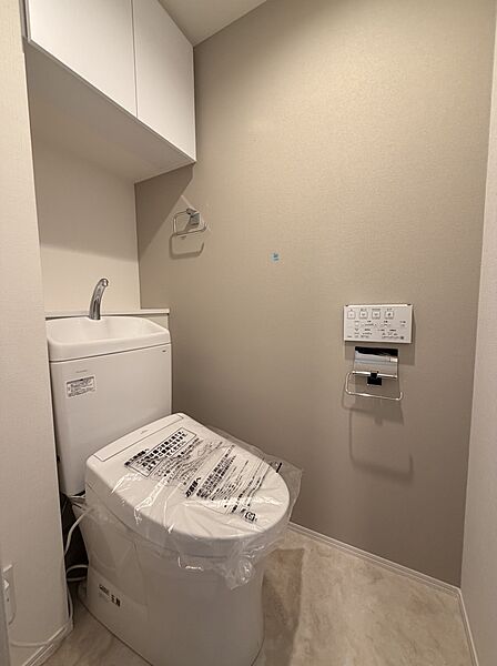 【トイレ】温水洗浄便座付きのトイレです。寒い時期でも温かな便座で快適に使うことができます。リモコンが壁に設置され、操作しやすい仕様です。