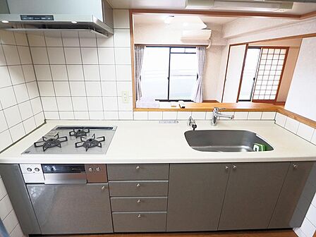 南向きの明るい対面キッチン。左手には勝手口があり外にゴミ箱が置けて便利です。ガスコンロとレンジフードは2020年8月に交換済みです。
