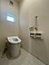 トイレ：窓から光が差し込む明るいトイレ空間。換気扇も備わり、いつも清潔に保てます。手すりも設置され、安心してお使いいただけます。