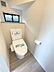 トイレ：採光・換気窓付きのトイレです。ウォシュレットと棚が備わっており、快適にお使いいただけます。