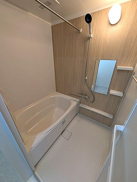 落ち着いた木目調の壁が印象的な浴室は、日々の疲れを癒す空間です。清潔感のある浴槽と使いやすいシャワーで、リラックスタイムをお過ごしください。