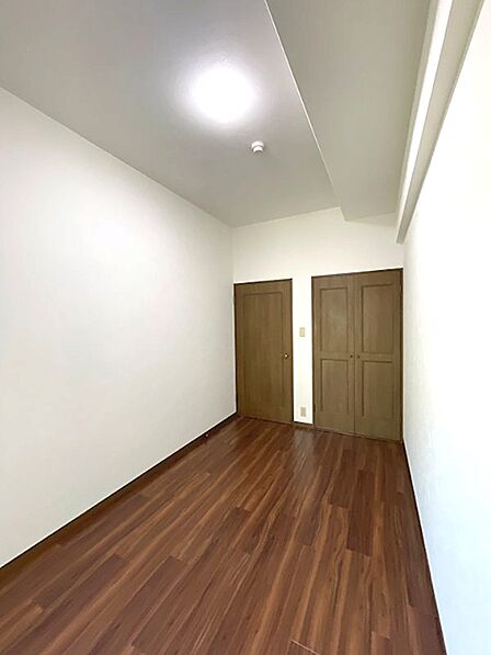 温かみのある木目調の床と白壁が印象的な洋室。収納も備わり、居心地の良いプライベート空間を演出します。