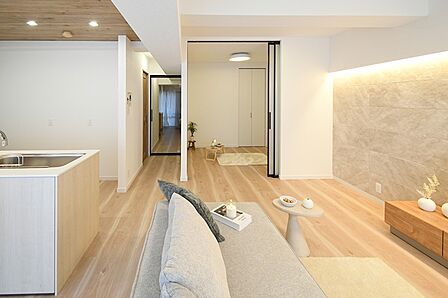 明るい木目と落ち着いた白を基調とした空間です。キッチンのカウンタートップやリビングの壁面アクセントが、上質感を演出します。