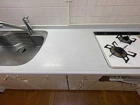 明るいワークトップと二口コンロで、日々の調理も快適に。収納も充実したキッチンです。