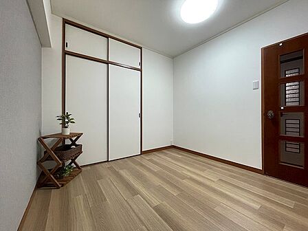 落ち着いた木目調の床と白い壁が、穏やかな空間を演出します。収納スペースも確保されており、すっきりとした暮らしが叶います。