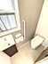 トイレ：明るく清潔感のあるトイレ空間。窓からの採光に加え、手洗いカウンター付きで快適に利用できます。壁には手すりも設置されており、安心です。