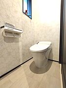 花柄のクロスが印象的なトイレ空間。手洗いカウンター付きで、清潔感と機能性を兼ね備えています。さりげない飾り窓が空間に彩りを添えます。