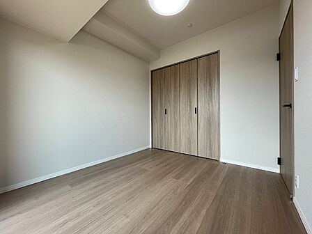 明るいフローリングとクローゼットを備えた居室は、多様な使い方が可能です。白を基調とした壁が空間を広く見せ、落ち着いた印象を与えます。