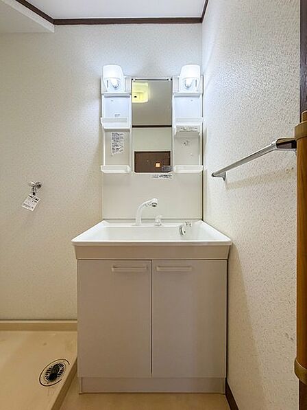 収納付きの洗面台と洗濯機置場を備え、身支度から洗濯まで使いやすい空間です。