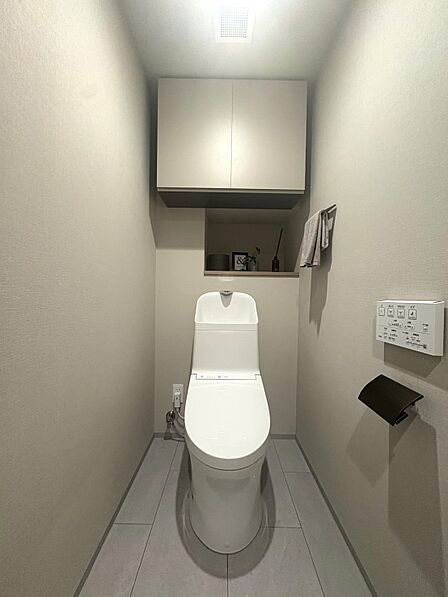 温水洗浄便座付トイレ。上部には収納スペースを設置しており、トイレットペーパーや掃除用品の収納が可能。