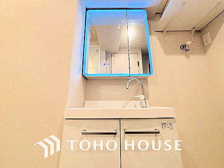 白を基調とした清潔感のある洗面室で朝の身支度を