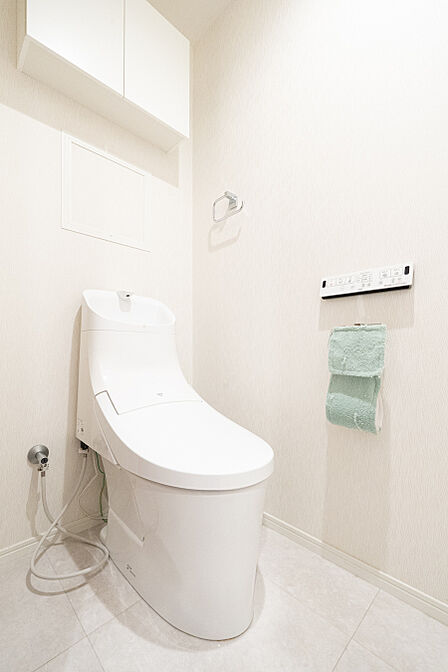 温水洗浄便座付きなので、快適にご使用いただけます。背面に吊り戸棚があり収納も充実しています。