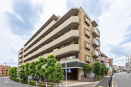 ベージュを基調としたタイル張りのマンションです。