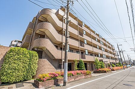 ベージュを基調としたタイル張りのマンションです。