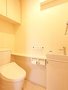 手洗いカウンターと収納を備えた、明るく使いやすいトイレです